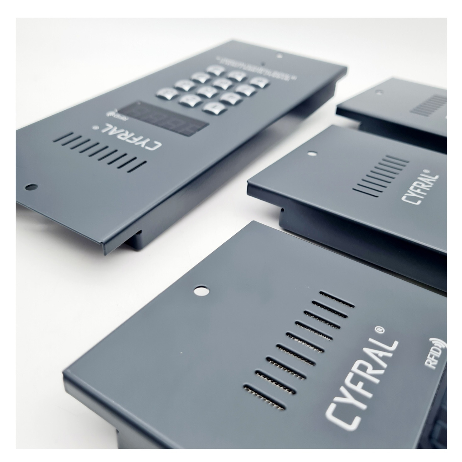 Antracytowe panele kontrolne z klawiaturą, wyświetlaczem i czytnikiem RFID, leżące na białym tle, prezentacja produktu.