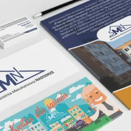 Zestaw materiałów reklamowych Spółdzielni Mieszkaniowej Nadodrze: wizytówki, ulotki, broszura informacyjna z budynkiem w tle, ołówek.
