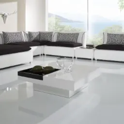 Biała, modułowa sofa z czarnymi poduszkami w nowoczesnym salonie. Błyszcząca podłoga, widok na jezioro i góry za oknem. Minimalistyczny design.