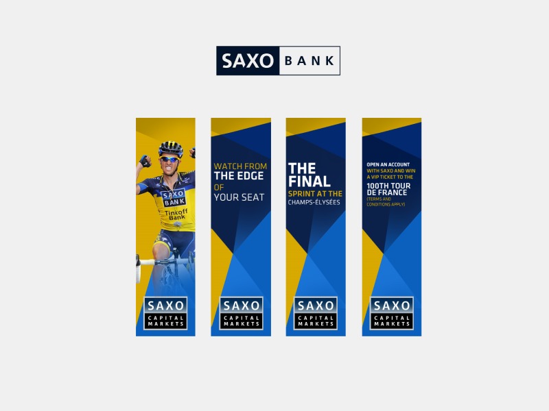 Cztery roll-upy reklamowe Saxo Bank Capital Markets, prezentujące kolarza w żółtej koszulce, hasła 'Watch from the edge of your seat', 'The Final Sprint at the Champs-Élysées' oraz ofertę wygrania...