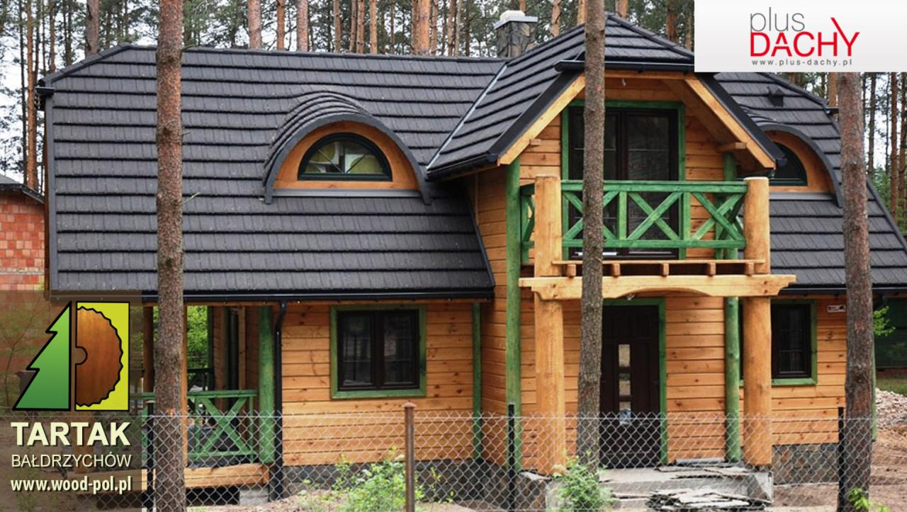 Drewniany dom z czarną dachówką karpiówką, zielonymi elementami wykończenia i oknem w kształcie półksiężyca, otoczony drzewami.