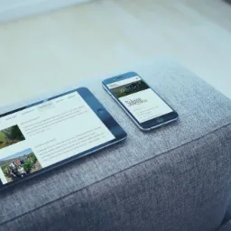 Tablet i smartfon z wyświetloną stroną internetową Solvino leżą na szarym, teksturowanym materiale. Widok z góry, oświetlenie studyjne, nowoczesny design.