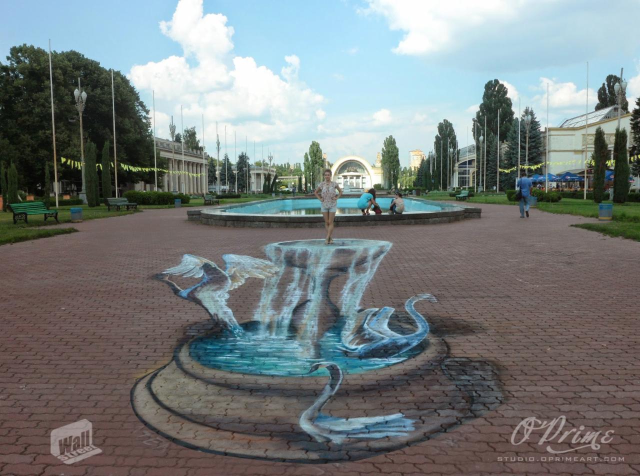 Park z iluzjonistycznym malowidłem 3D na chodniku przedstawiającym fontannę z łabędziami, na której stoi młoda kobieta, a w tle widać prawdziwą fontannę.