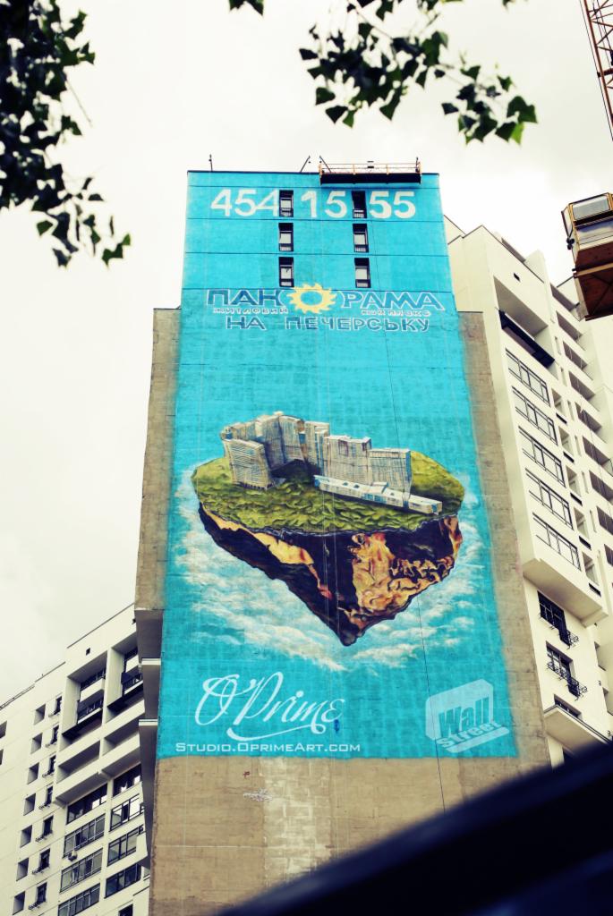 Wielkoformatowy mural reklamowy na ścianie budynku w Zielonej Górze, przedstawiający futurystyczną wyspę z budynkami, namalowany w jasnych, pastelowych kolorach.