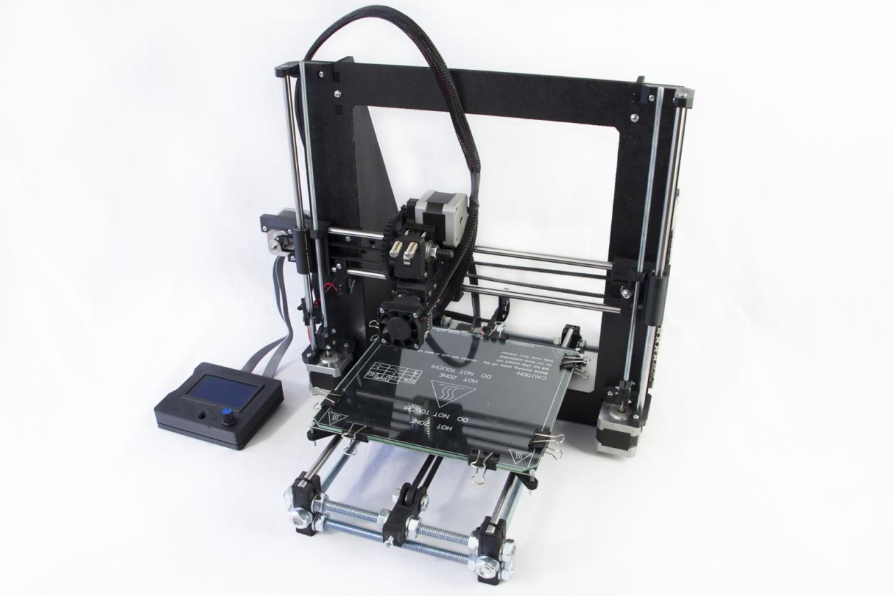 Czarna drukarka 3D z wyświetlaczem LCD w Rzeszowie, widoczna płyta grzewcza z ostrzeżeniem o wysokiej temperaturze na białym tle.