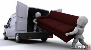 Wnętrze busa transportowego z dwoma manekinami w trakcie załadunku bordowej sofy. Widok z tyłu pojazdu, jasne tło.