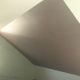 Pomalowane poddasze ze skosami w odcieniach szarości i bieli, widoczne okno. Świeżo odnowione wnętrze ze starannie wykończonymi powierzchniami.