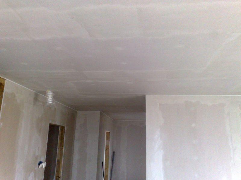 Ściany i sufit po szpachlowaniu, przygotowane do malowania. Widoczne łączenia płyt gipsowo-kartonowych i fragment wentylacji. W tle ościeżnice drzwiowe.