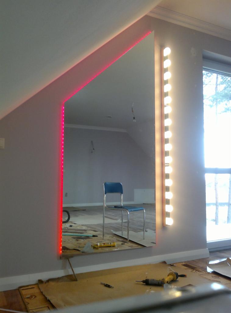 Lustro z oświetleniem LED (czerwone i białe) w pokoju z oknem. Widoczne narzędzia sugerują montaż oświetlenia.