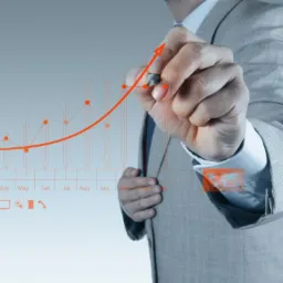 Mężczyzna w garniturze rysuje rosnący wykres na interaktywnym ekranie, symbolizujący wzrost w kampaniach reklamowych.