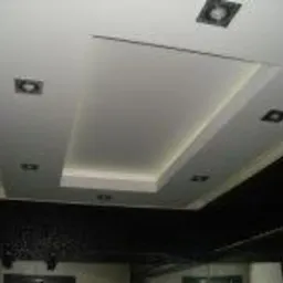 Podwieszany sufit z oświetleniem punktowym i wnęką oświetloną taśmą LED, widok z dołu.