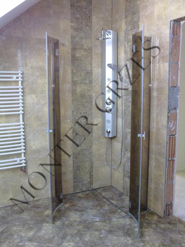 Wykończona kabina prysznicowa z panelami szklanymi i hydromasażem, wyłożona mozaiką w odcieniach beżu i brązu. Widoczny grzejnik drabinkowy.