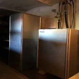 Dwa metalowe moduły rekuperacji Daikin w piwnicy, z widocznymi rurami doprowadzającymi i odprowadzającymi powietrze.