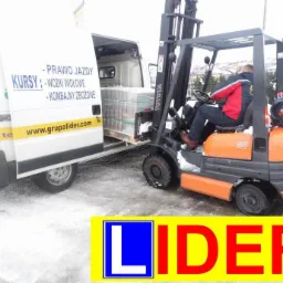 Operator wózka widłowego Toyota ładuje paletę z materiałami do białego furgonetki z napisem 'Kursy: Wózki widłowe' na otwartych drzwiach, zimowa sceneria z śniegiem na ziemi i logo firmy 'LIDER'...