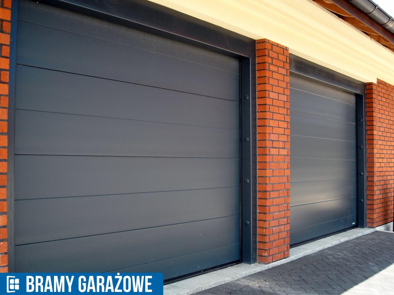 Dwie szare, segmentowe bramy garażowe z ceglanymi filarami, widoczne z perspektywy lekko z dołu. Brama po lewej stronie jest wyraźniejsza.