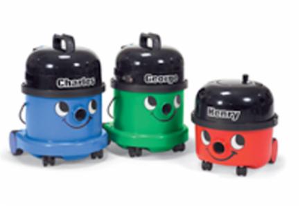 Trzy kolorowe odkurzacze biurowe z namalowanymi uśmiechniętymi buziami: niebieski Charles, zielony George i czerwony Henry, stojące na białym tle.