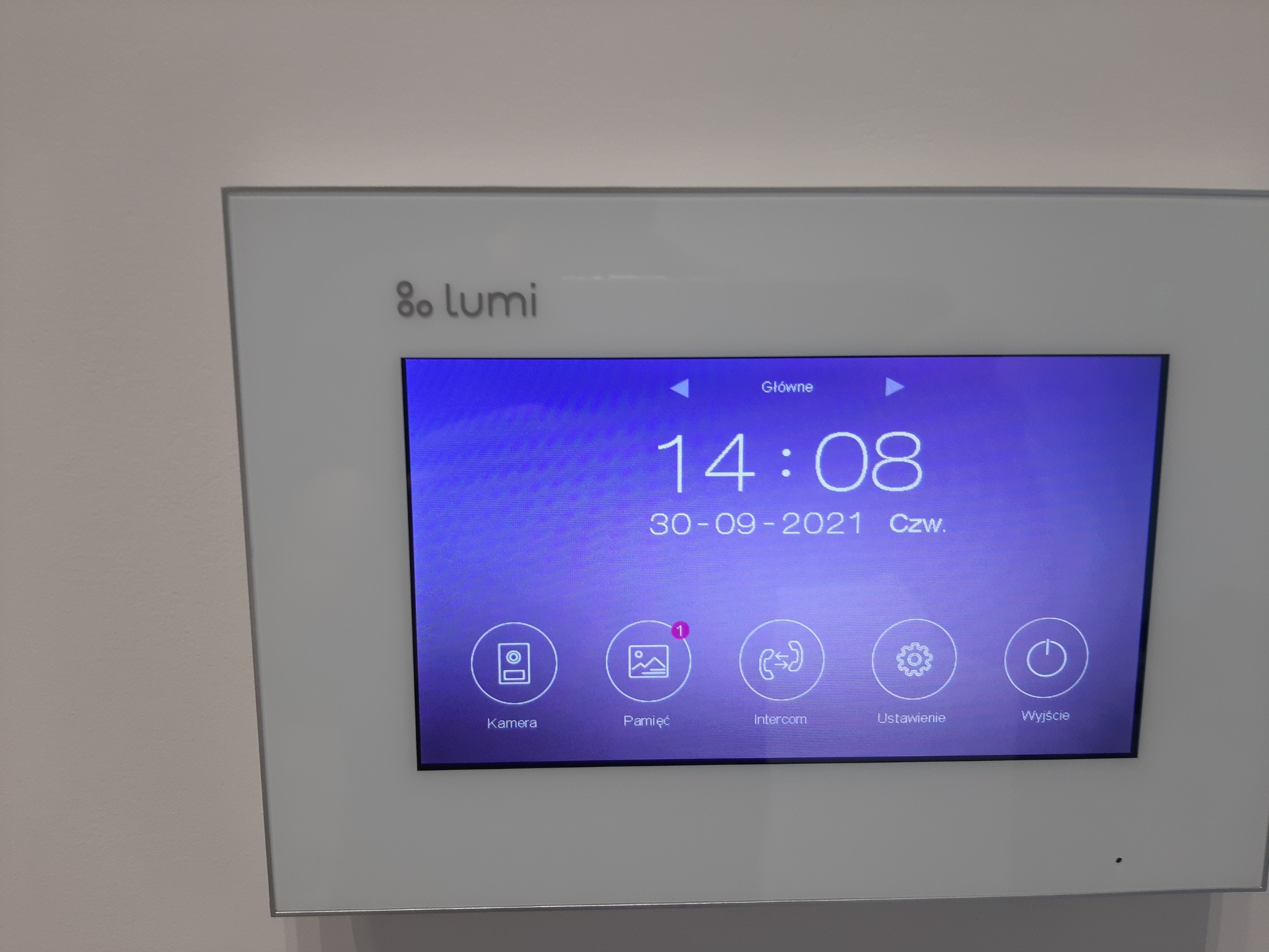 Panel wideodomofonu Lumi z ekranem wyświetlającym godzinę, datę i ikony menu: kamera, pamięć, intercom, ustawienia i wyjście.