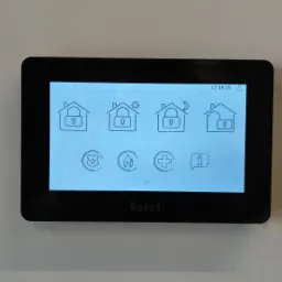 Panel sterowania systemem alarmowym firmy Satel w Głogowie, z ikonami stanu zabezpieczeń domu: dzień, noc, pełne zabezpieczenie i rozbrojony.