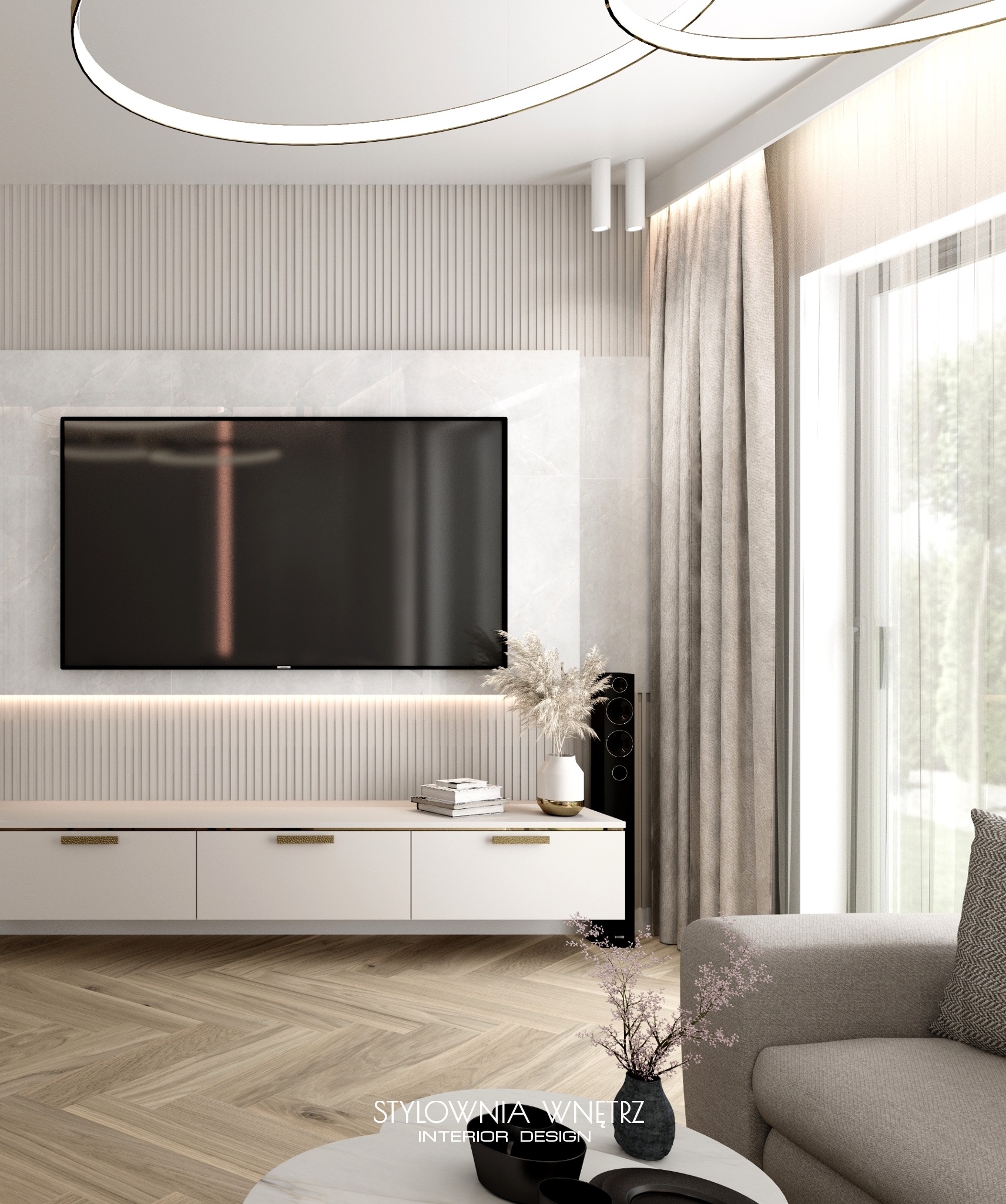 Jasne, minimalistyczne wnętrze salonu z telewizorem na ścianie z marmuru, białą szafką RTV z złotymi uchwytami, parkietem w jodełkę i dekoracyjną lampą sufitową