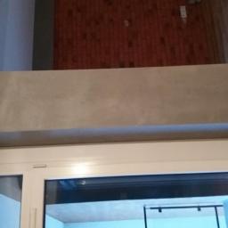 REMODOM SPÓŁKA Z OGRANICZONĄ ODPOWIEDZIALNOŚCIĄ - Szara, gładka ściana nad białym oknem w Jarosławiu, z widocznym fragmentem ceglanej ściany na górze.