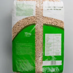 Worek 15 kg pelletu drzewnego o średnicy 6 mm, z widoczną etykietą zawierającą dane techniczne i adres strony internetowej producenta, na szarym tle.