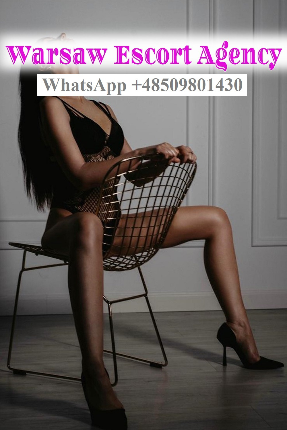 Kobieta siedzi na metalowym krześle w bieliźnie i szpilkach, w tle ściana z dekoracyjną listwą, widoczny napis Warsaw Escort Agency i numer telefonu.