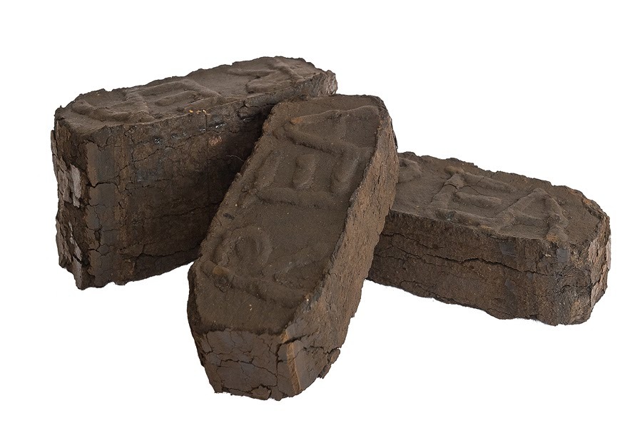 Trzy bryły opału z wytłoczonym napisem, ułożone na białym tle, widoczne pęknięcia na powierzchni.