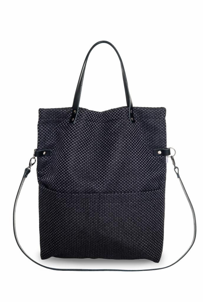 Ciemna, tekstylna torba shopper z plecionym wzorem, skórzanymi uchwytami i paskiem na ramię, zaprezentowana na białym tle w centralnym ujęciu.