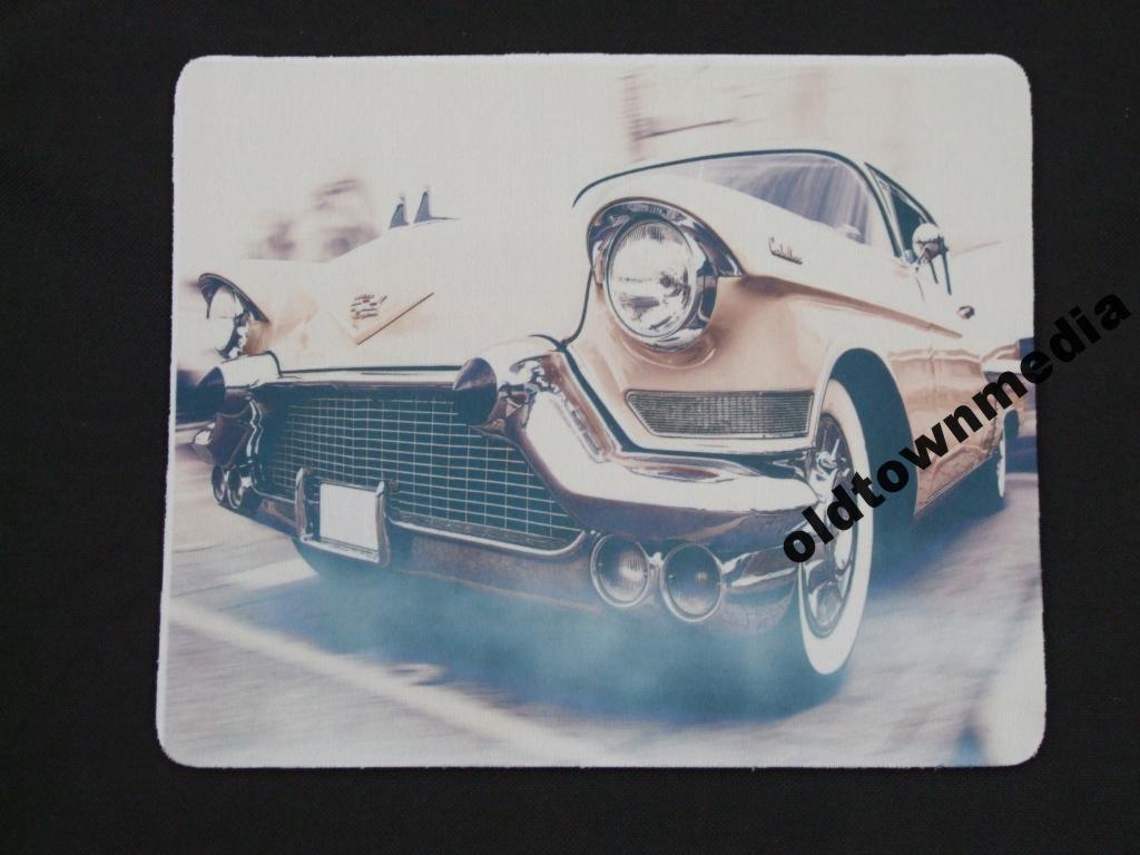 Podkładka pod mysz z nadrukiem retro samochodu Cadillac, z widocznym logo firmy 'oldtownmedia' w prawym dolnym rogu. Styl vintage, stonowane kolory.