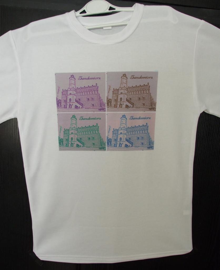 Biała koszulka z nadrukiem Ratusza w Sandomierzu w czterech kolorach, zawieszona na wieszaku. Grafika w stylu retro z nazwą miasta.
