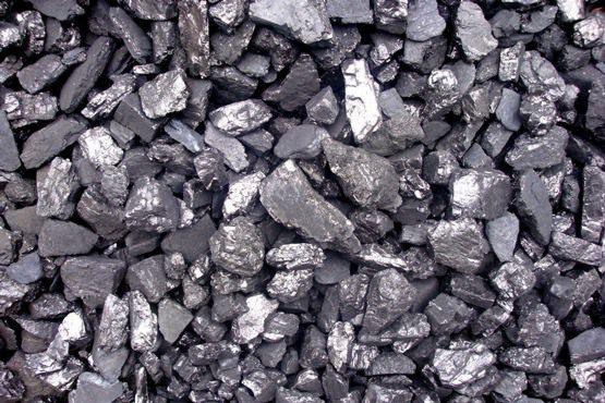 Błyszczący węgiel kamienny w dużym zbliżeniu. Różne frakcje węgla o nieregularnych kształtach, z widocznymi refleksami światła na powierzchni.