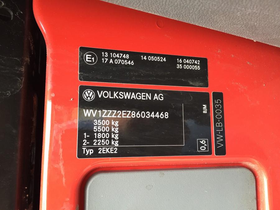 Tabliczka znamionowa VW Crafter z detalami technicznymi, takimi jak waga, numer VIN i typ, umieszczona na czerwonym elemencie konstrukcyjnym pojazdu.