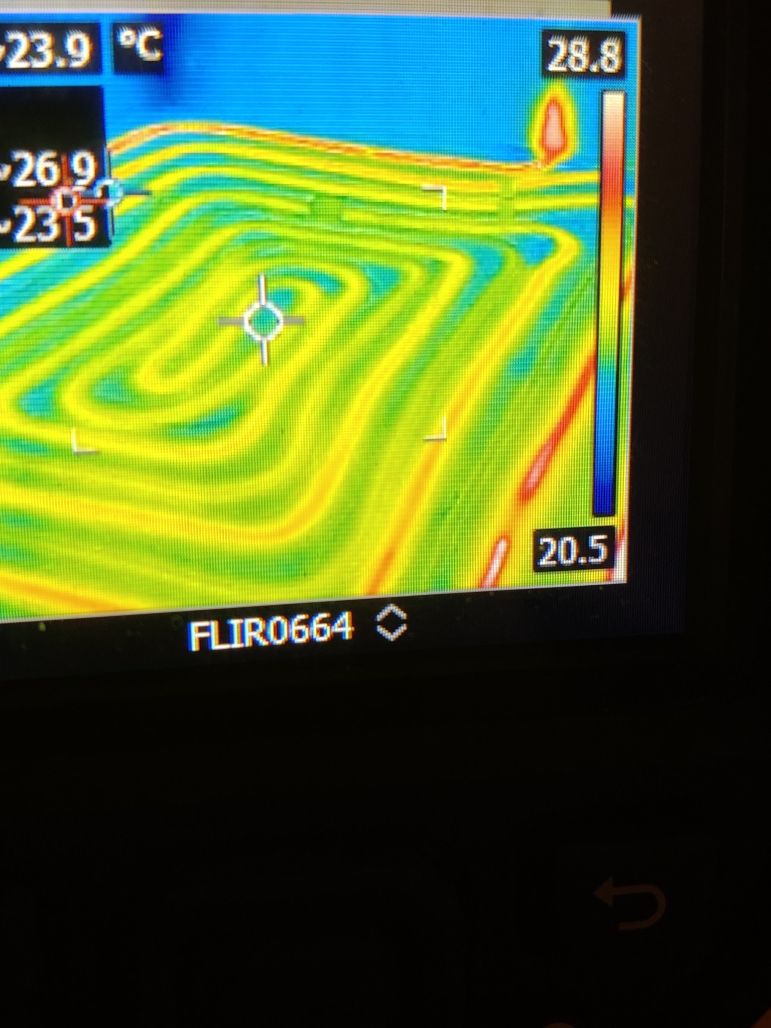 Termowizyjny obraz rur ułożonych w kształt spirali, wskazujący na rozkład temperatur w systemie grzewczym, z widocznymi odczytami temperatur w stopniach Celsjusza.