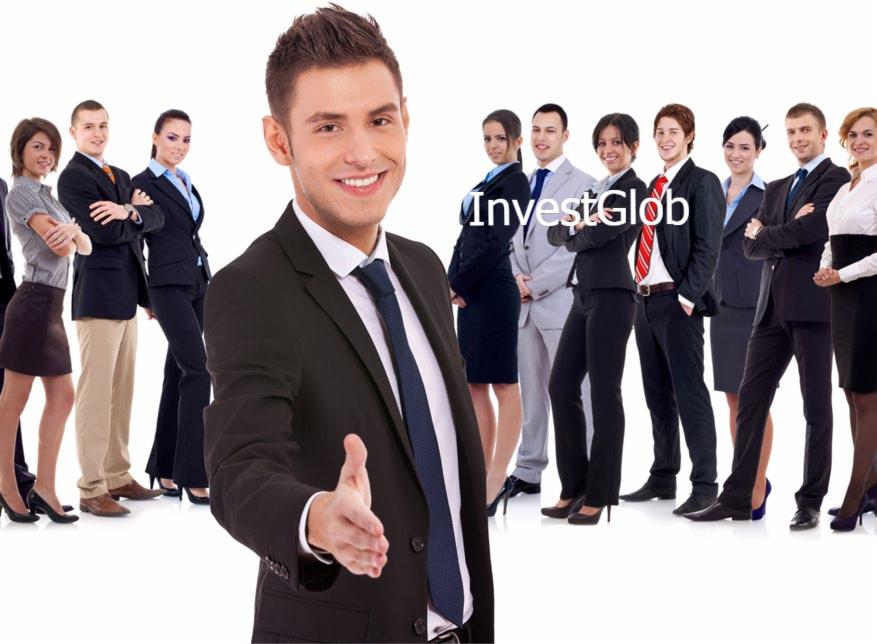 Uśmiechnięty mężczyzna w garniturze wyciąga rękę na powitanie, w tle grupa osób w strojach biznesowych. Logo 'InvestGlob' nałożone na zdjęcie.