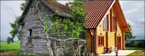 Dom przed i po remoncie w Giżycku: Stara drewniana chata obok nowoczesnego domu z bali z czerwoną dachówką. Kontrast tekstur i kolorów, od zaniedbania do odnowy.