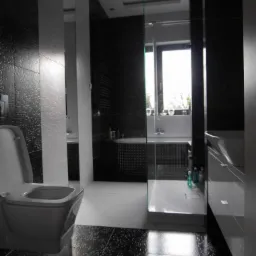 Nowoczesna łazienka z czarno-białą mozaiką podłogową, kabiną prysznicową ze szklaną ścianą i białymi elementami wyposażenia. Minimalistyczny design.