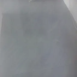 Świeżo położone, szare płytki na ścianie, widoczne spoiny, oświetlenie górne.