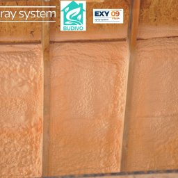 BUDIVO - Poddasze ocieplone pianką PUR, widoczne drewniane belki konstrukcyjne i równomiernie nałożona warstwa izolacji w kolorze beżowym. System natryskowy EXY.