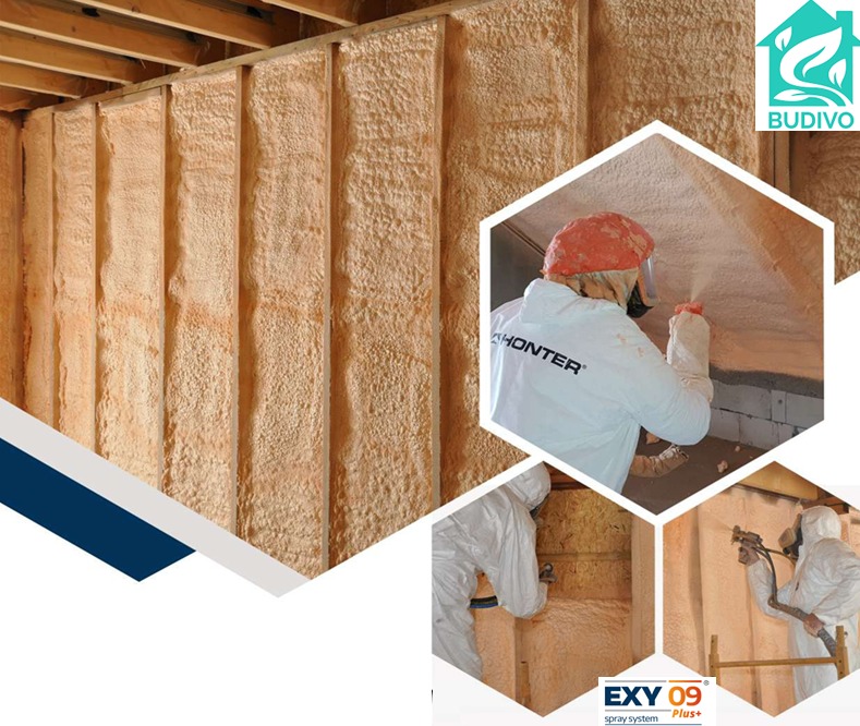 Poddasze po natrysku pianki PUR, widoczne drewniane belki stropowe. W tle pracownik w kombinezonie podczas aplikacji pianki.