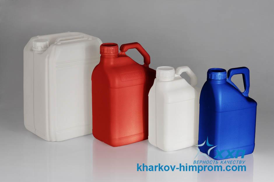 Plastikowe kanistry o różnej pojemności i kolorach (biały, czerwony, niebieski) ustawione na gładkiej powierzchni. Widoczne logo producenta.