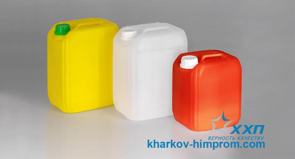 Trzy plastikowe kanistry: żółty z zieloną zakrętką, biały i czerwony z białymi zakrętkami. Widoczne logo firmy Kharkiv-himprom.com. Produkty chemiczne.
