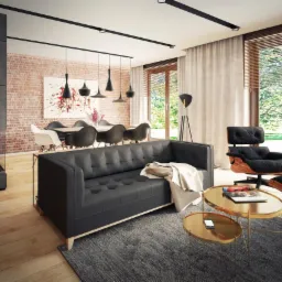 Nowoczesny salon z szarą sofą, złotymi stolikami kawowymi i ceglaną ścianą w tle, oświetlony wiszącymi lampami i naturalnym światłem z okna.