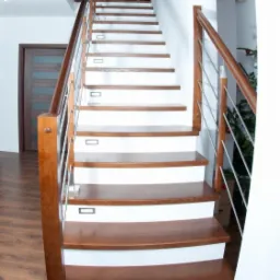 Nowoczesne schody z drewnianymi stopniami i białymi podstopnicami, oświetleniem LED i balustradą z elementami drewnianymi i nierdzewnymi w jasnym wnętrzu.