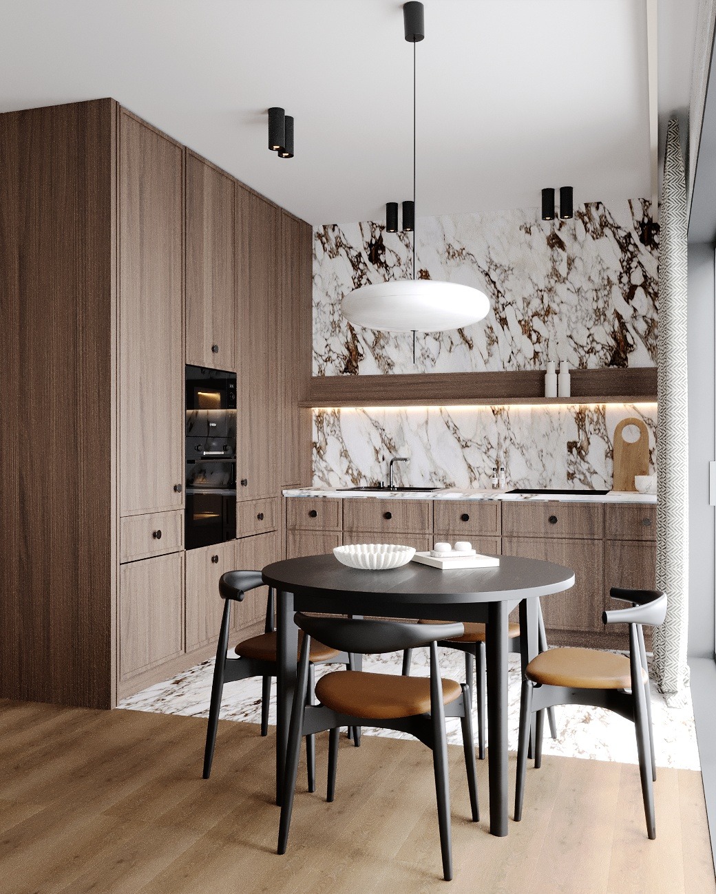 Nowoczesna kuchnia z marmurową ścianą, drewnianymi szafkami i okrągłym stołem z czarnymi krzesłami z brązowymi siedziskami. Nad stołem wisi owalna biała lampa. Na blacie kuchennym widoczne...