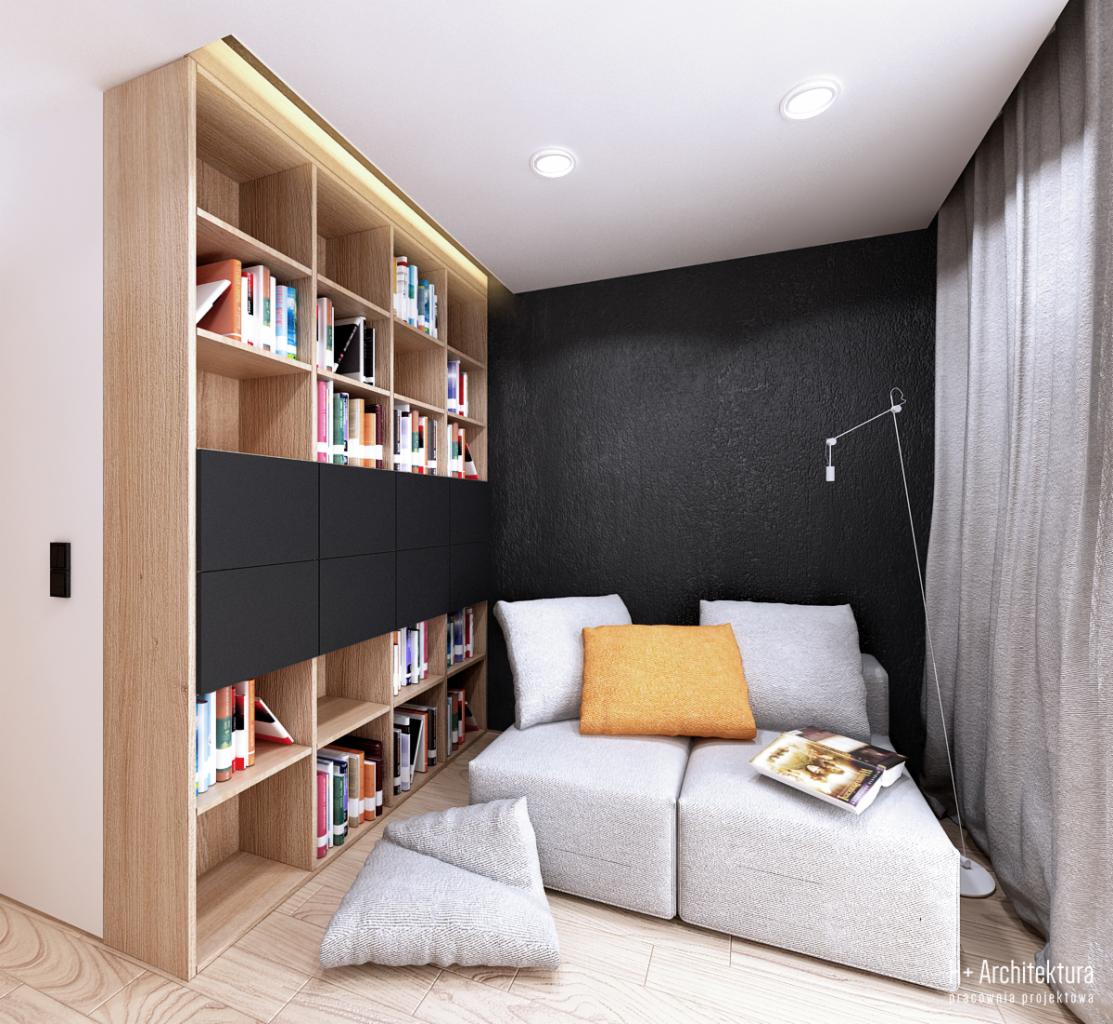 Nowoczesna biblioteczka z jasnego drewna z czarnymi szafkami, narożna sofa z pomarańczową poduszką i książką w minimalistycznym pokoju z czarną ścianą i lampą podłogową.