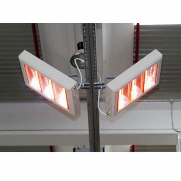 Dwa białe promienniki ciepła zamontowane na metalowej konstrukcji pod sufitem. Widoczne przewody i elementy montażowe.