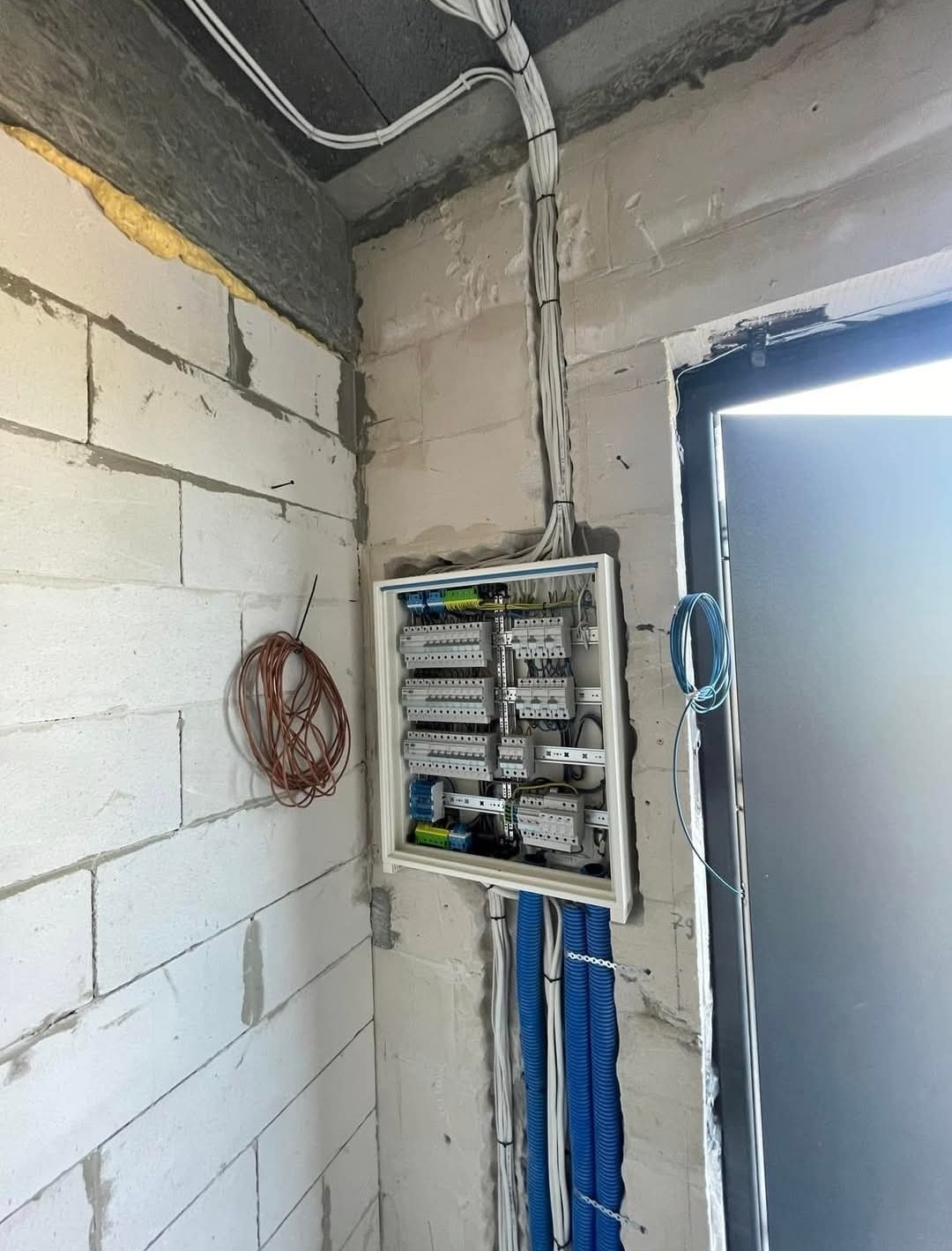 Rozdzielnica przy wejściu na etapie montażu. Kable w peszlach uporządkowane, gotowe do podłączenia osprzętu