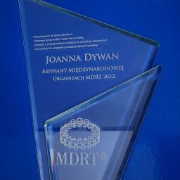 FHU Joanna Dywan - Szklana statuetka MDRT dla Joanny Dywan, aspiranta międzynarodowej organizacji z 2022 roku, symbolizująca profesjonalizm w sprzedaży ubezpieczeń.