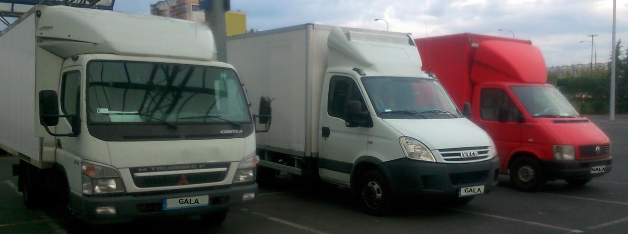 Trzy busy transportowe różnych marek i kolorów (biały, czerwony) zaparkowane obok siebie w Lublinie. Na każdym z nich widnieje nazwa firmy 'GALA'.