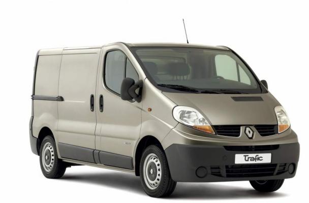 Renault Trafic w kolorze beżowym, widok z przodu i boku, na białym tle. Widoczne detale: antena, lusterka, opony. Auto zadbane, gotowe do transportu.